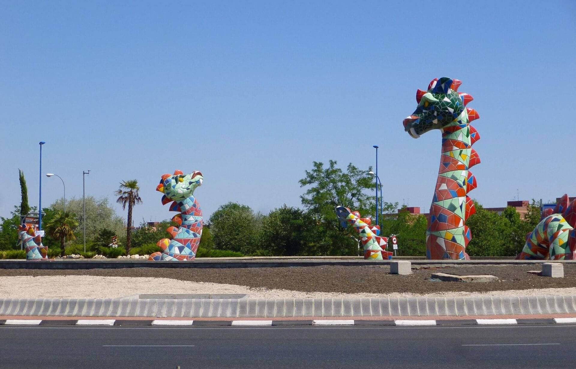 Nensi, el monstruo de Leganés: cabezas y cuerpo de mosaico de colores en una rotonda con palmeras