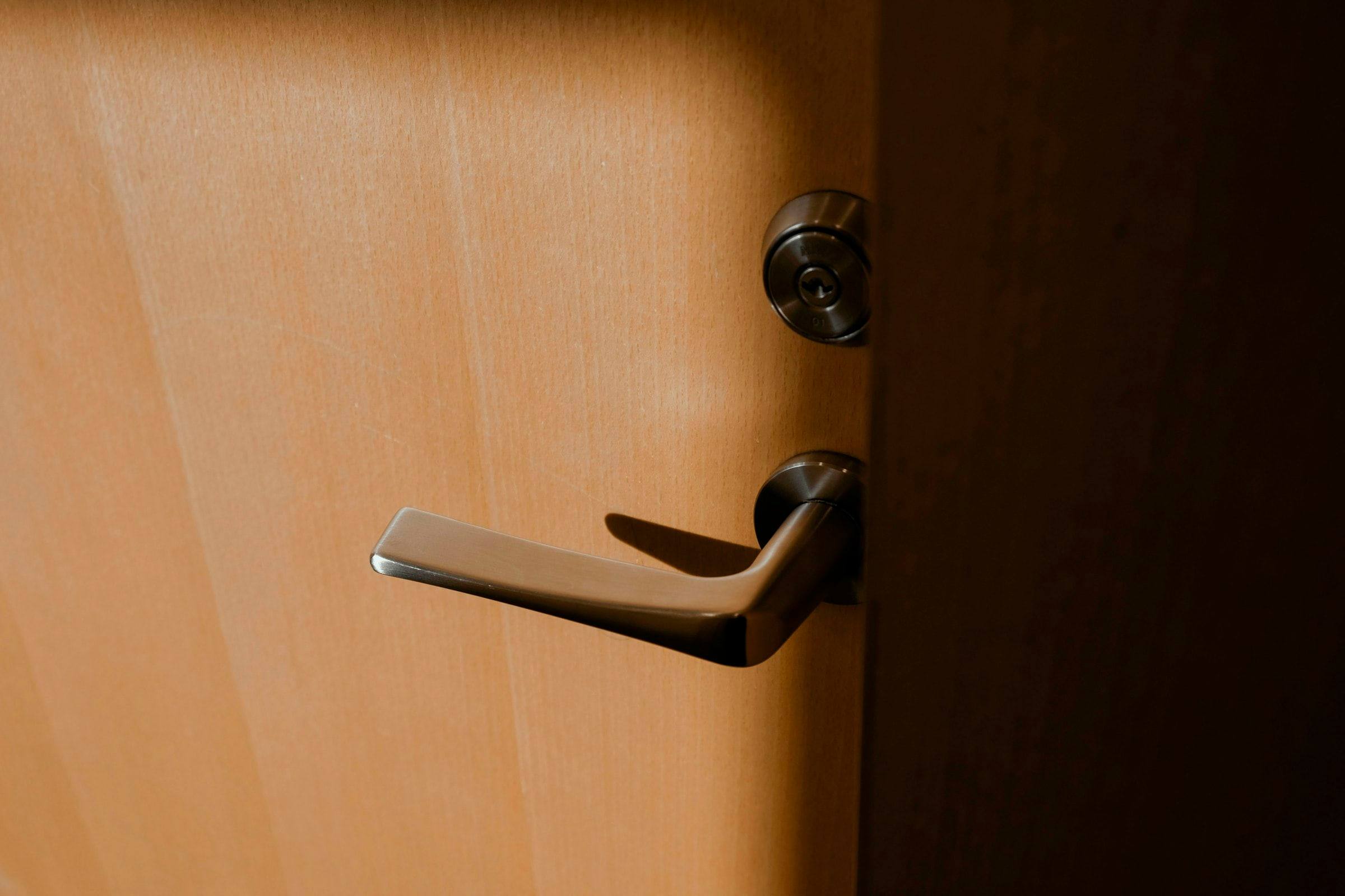 Manilla y bombín de una puerta de madera de una vivienda